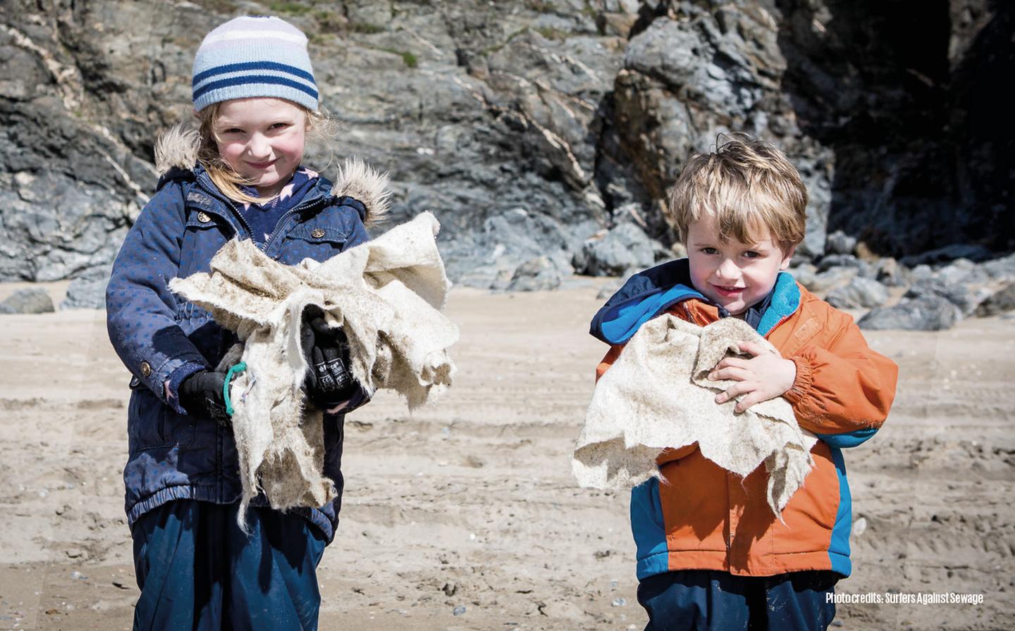 Two young children helping to clear a UK beach of litter